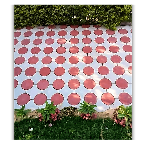 Pavés décoratifs rouges et blancs installés dans un jardin résidentiel à Dakar