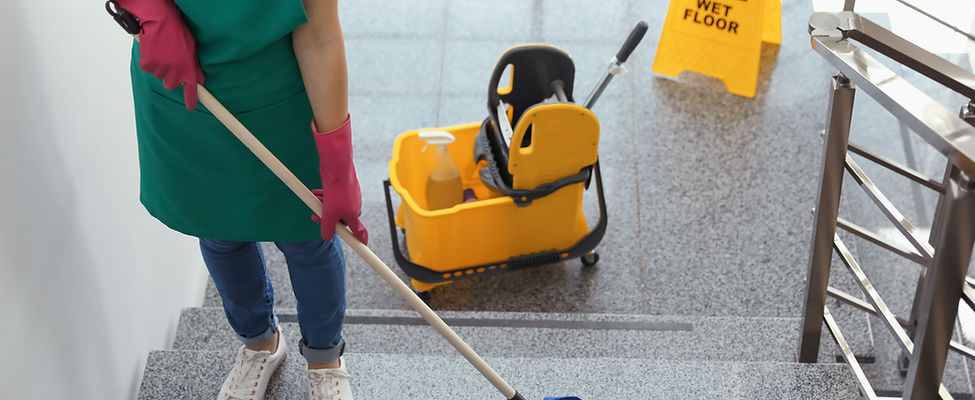 Young woman with mop cleaning stairs