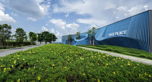 Main entrance with wave pattern design and lush green shrubs at Siri Place, Rangsit.
