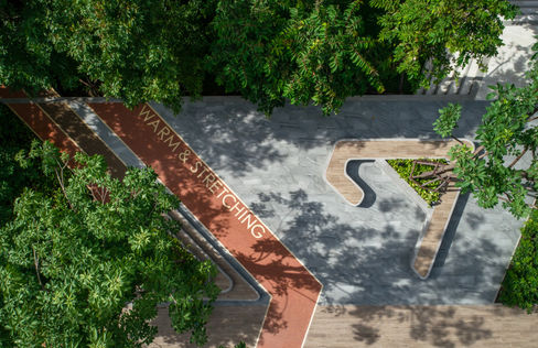 Shaded outdoor fitness and seating area surrounded by greenery at Plum Alive 2.