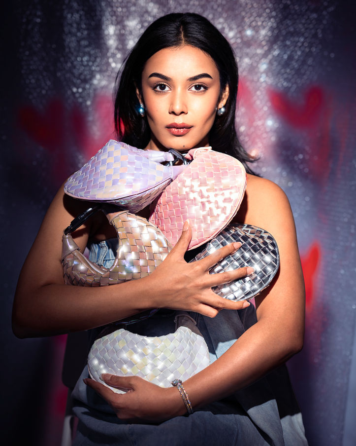 Woman holding multiple sequined fashion handbags