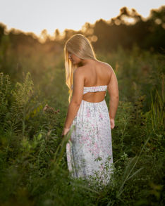 Senior girl in a floral dress during golden hour.
