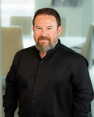 Professional branding headshot of a bearded man in black