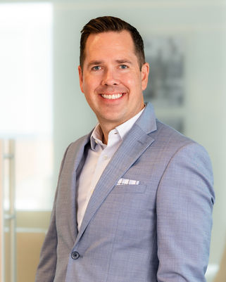 Professional branding headshot of a smiling man in a suit.