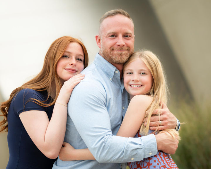 Father hugging his two daughters for a family portrait