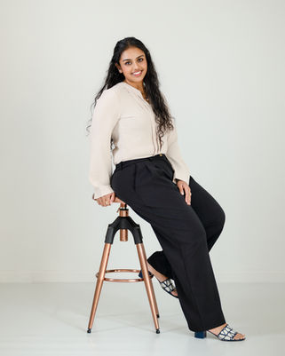 Smiling woman in branding headshot sitting on a stool