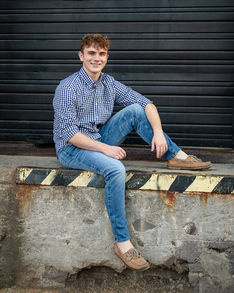 Young man sitting on a loading dock in an urban setting.