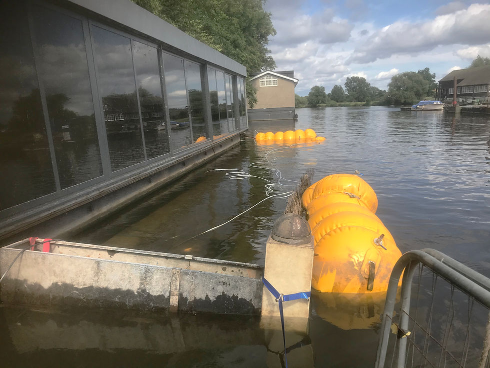 A sunken garden pontoon beside a houseboat is being raised using airbags