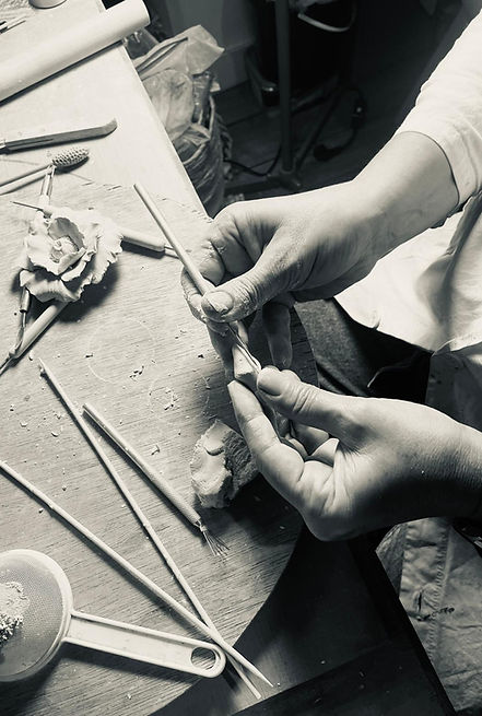 Mains d'Anne-Sophie Gorlier façonnant une fleur en porcelaine dans son atelier de céramique
