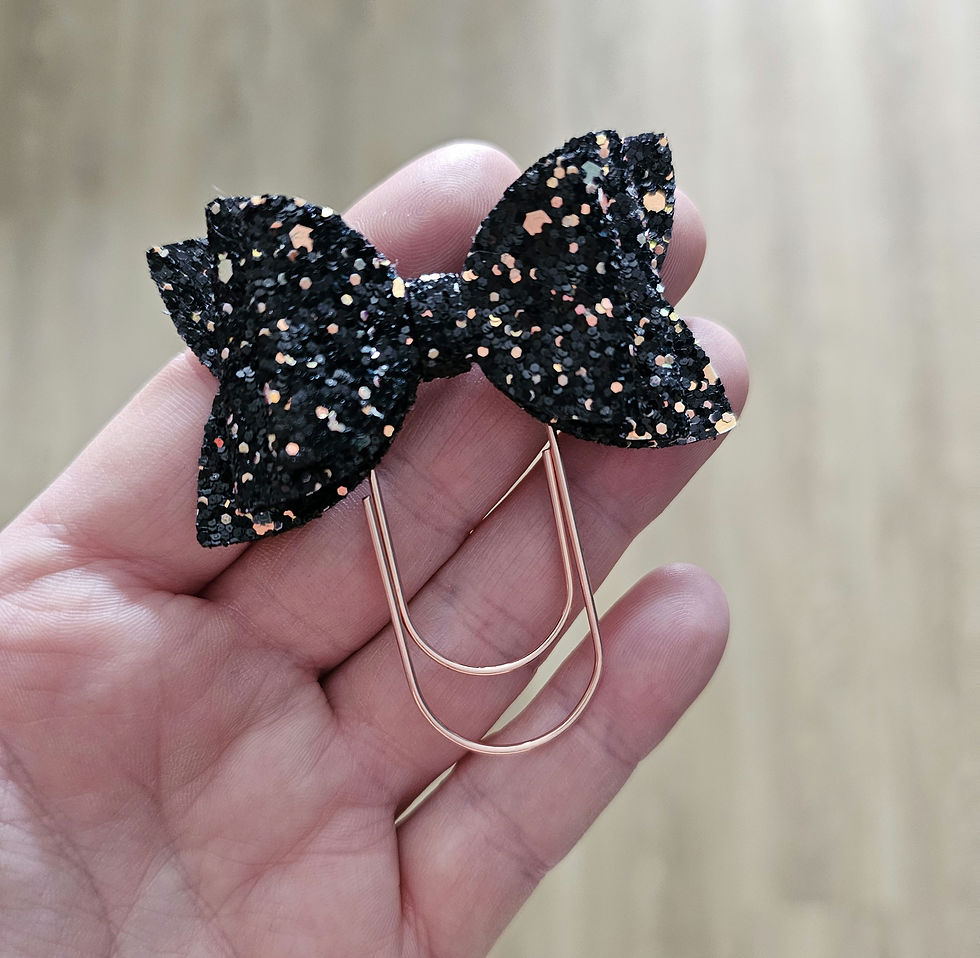 A Black and Rose Gold Glitter Layered Bow Attached to a Rose Gold Planner Clip.