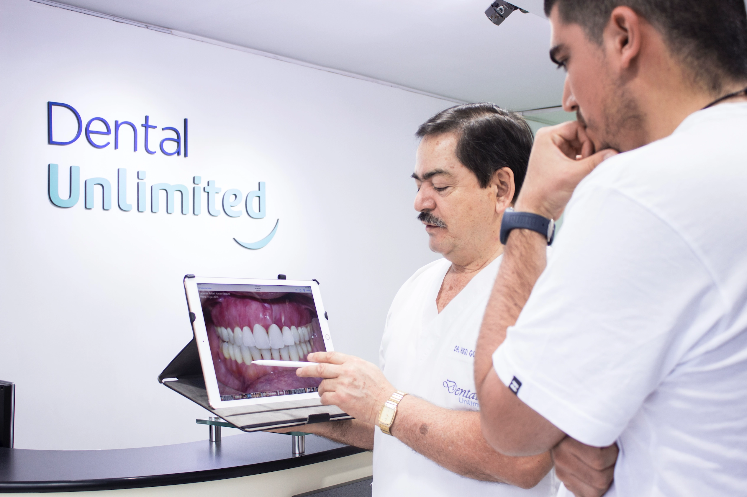 Dr. González explicando el plan de tratamiento a un paciente.
