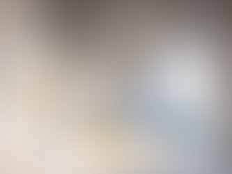 Modern interior with archway, blue sectional sofa, yellow pouf, abstract painting, and minimal decor. Light, calming atmosphere.