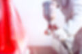 Close-up of spray gun with red paint pai