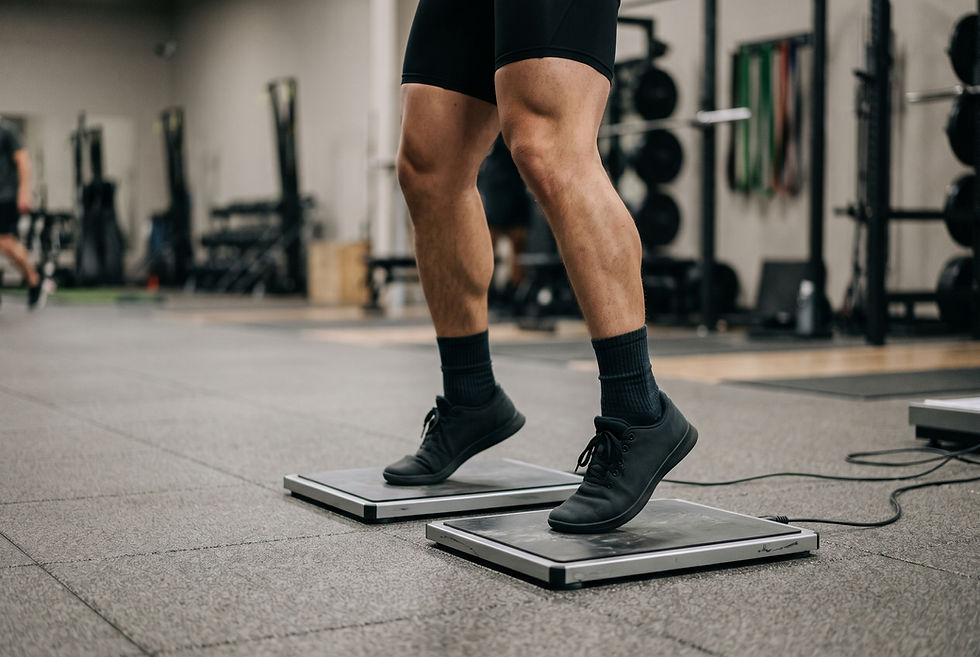 Close-up of an athlete's feet taking off from twin force plates during a countermovement jump test, part of the preseason physical testing battery.