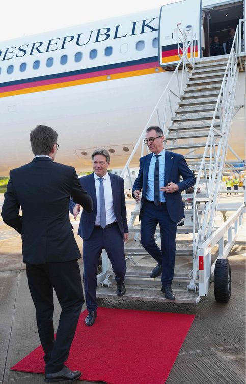 Robert Habeck und Cem Özdemir steigen aus dem Reigerungsflieger und laufen über den roten Teppich