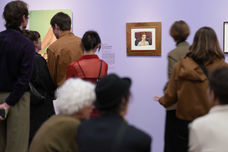 Viele Menschen betrachten ein Exponat der Ausstellung - von hinten fotografiert.