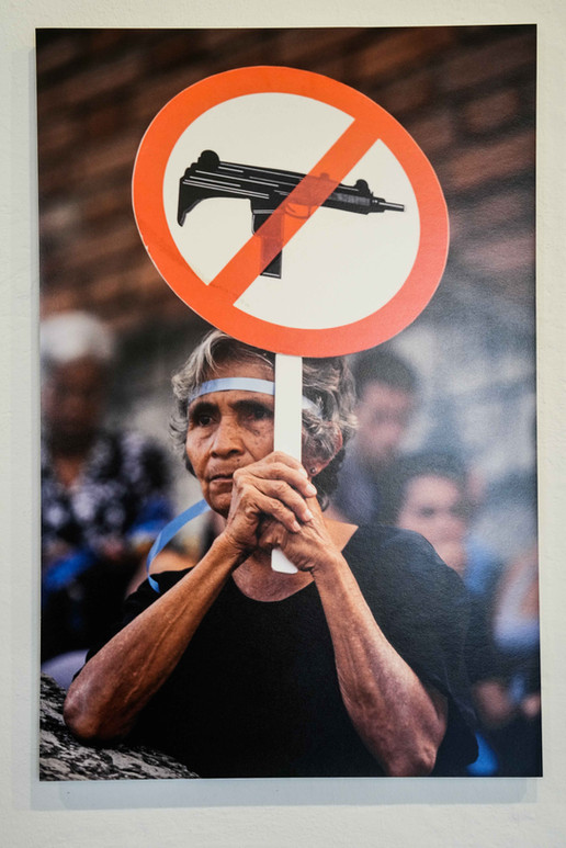 Person hält Schild mit durchgestrichener Waffe