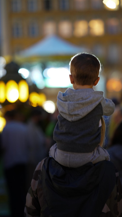 Kind auf Schultern, das Lichter betrachtet