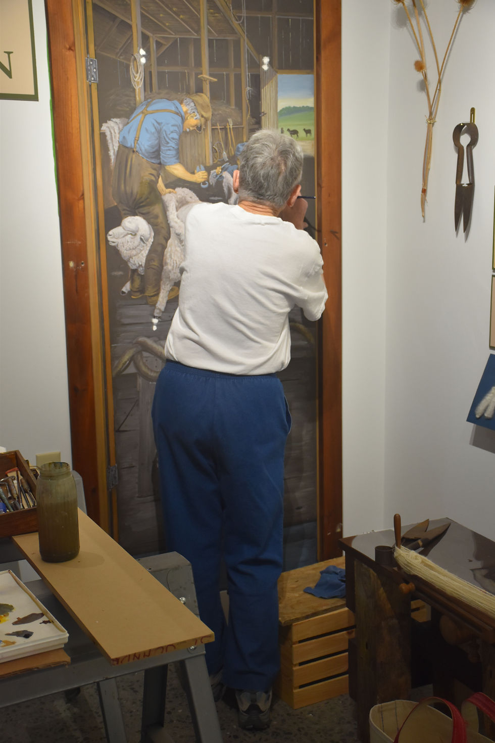 Robin Rothman touches up sheep painting.