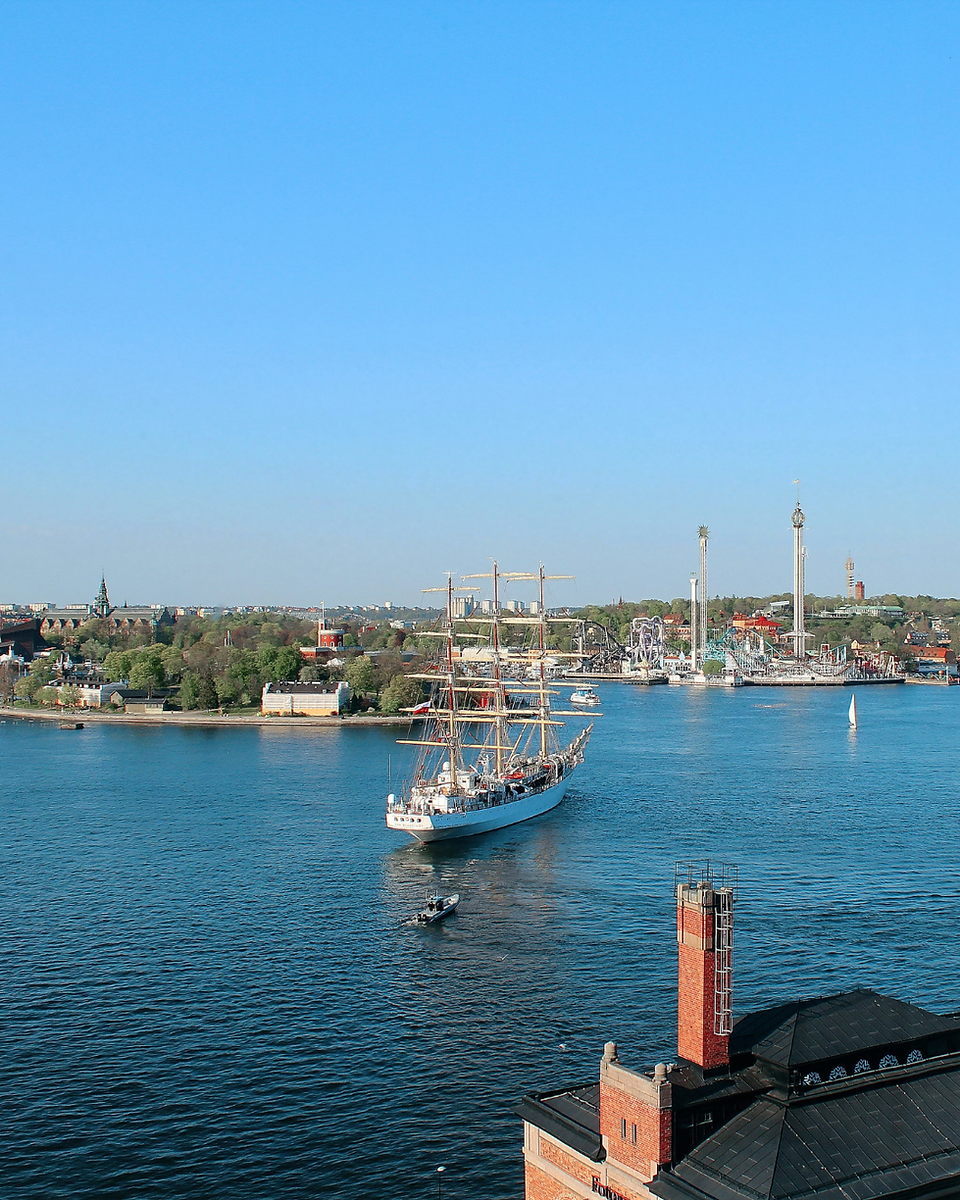 Stockholm i solsken och båt i vattnet med Gröna Lund i bakgrunden..