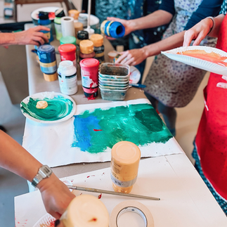 Personer plockar med akrylfärg och papper.