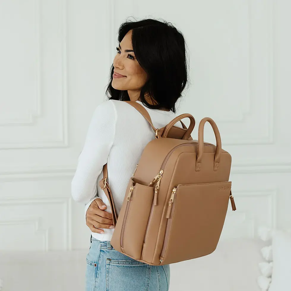Woman wearing a tan diaper bag, curated mom deals.