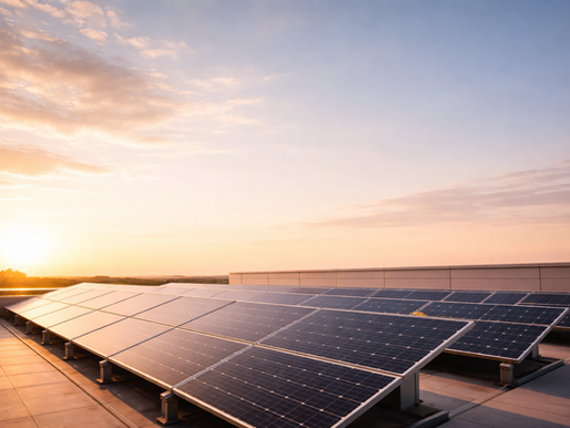 Solar panels installed on a rooftop capture sunlight during sunset under a clear sky.