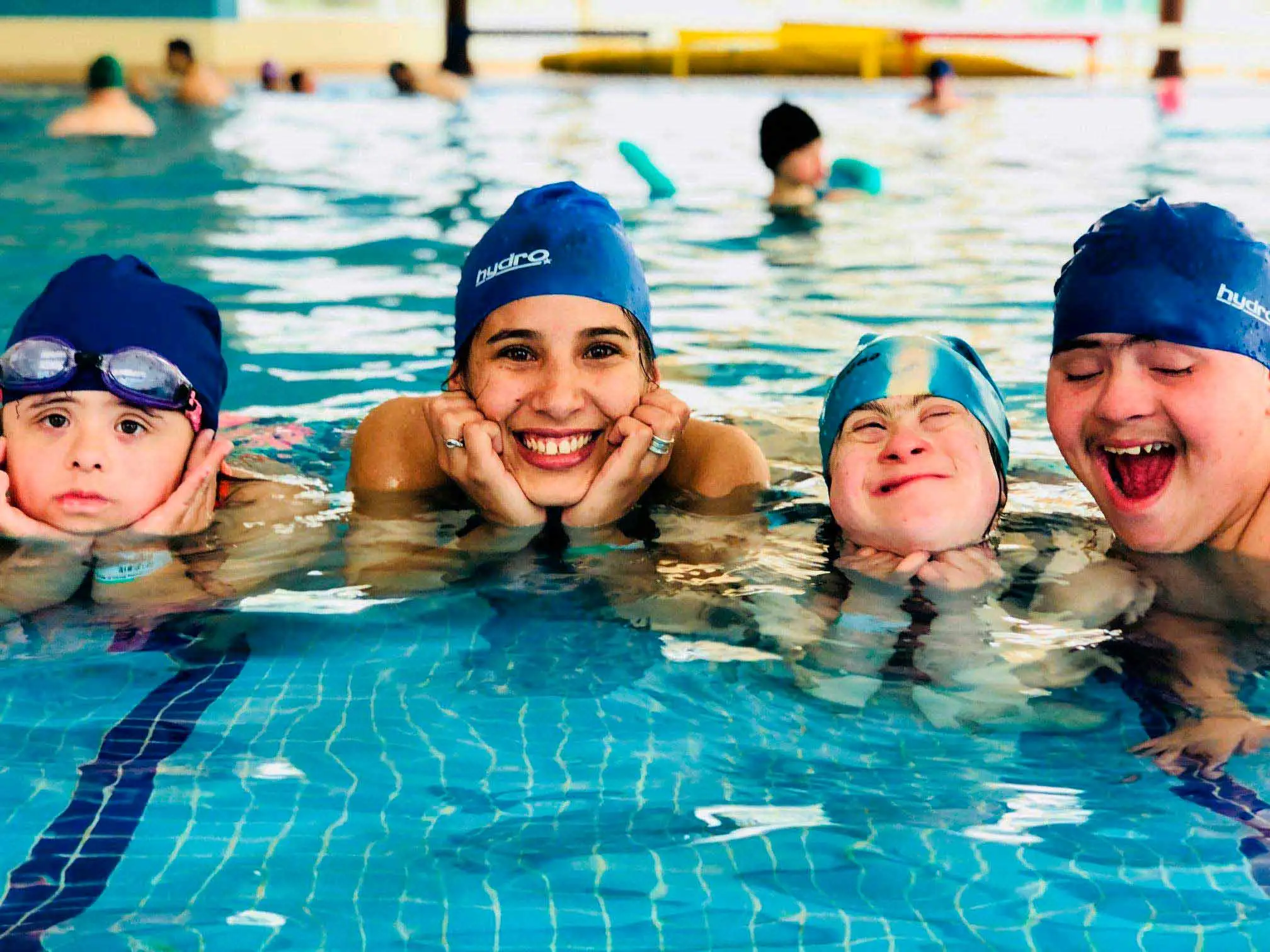 Personas con y sin discapacidad posando felices en una piscina