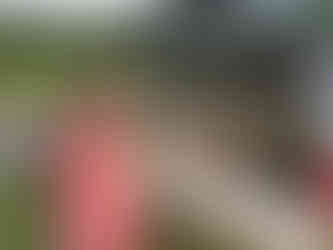 Smiling farm interns stand next to an open pickup truck with harvested garlic