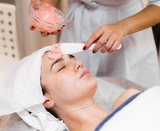 cosmetologist-applies-alginate-mask-with-spatula-face-woman.jpg