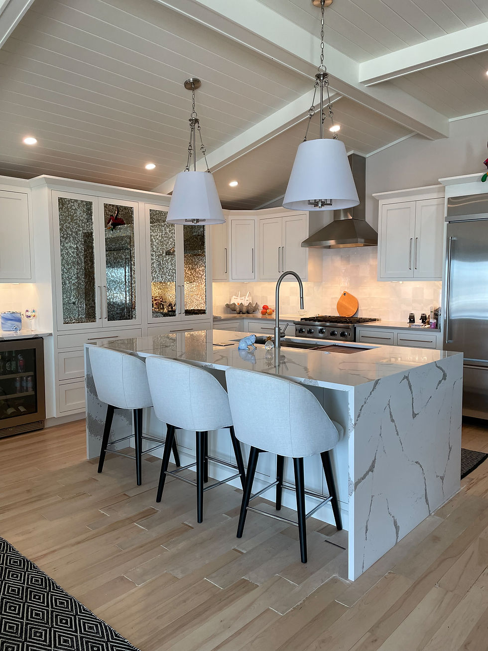 White Kitchen. Sink in Island. Waterfall Quartz Countertops.