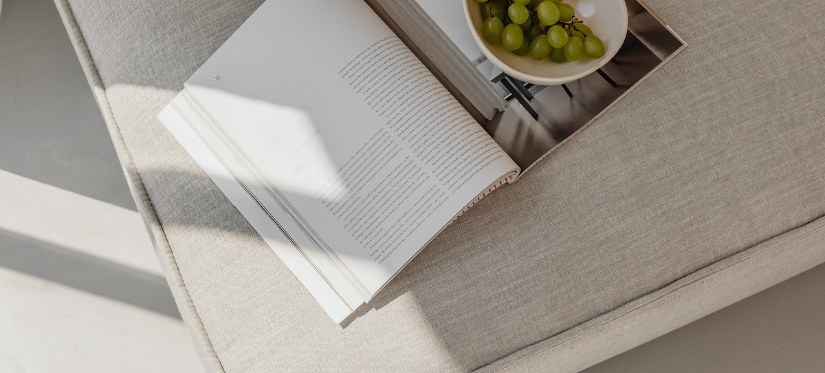 Book and grapes on ottoman