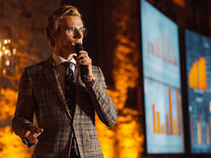 A professional speaker engaging in authentic stage presence, demonstrating the transition from rigid slide presentations to strategic audience connection.