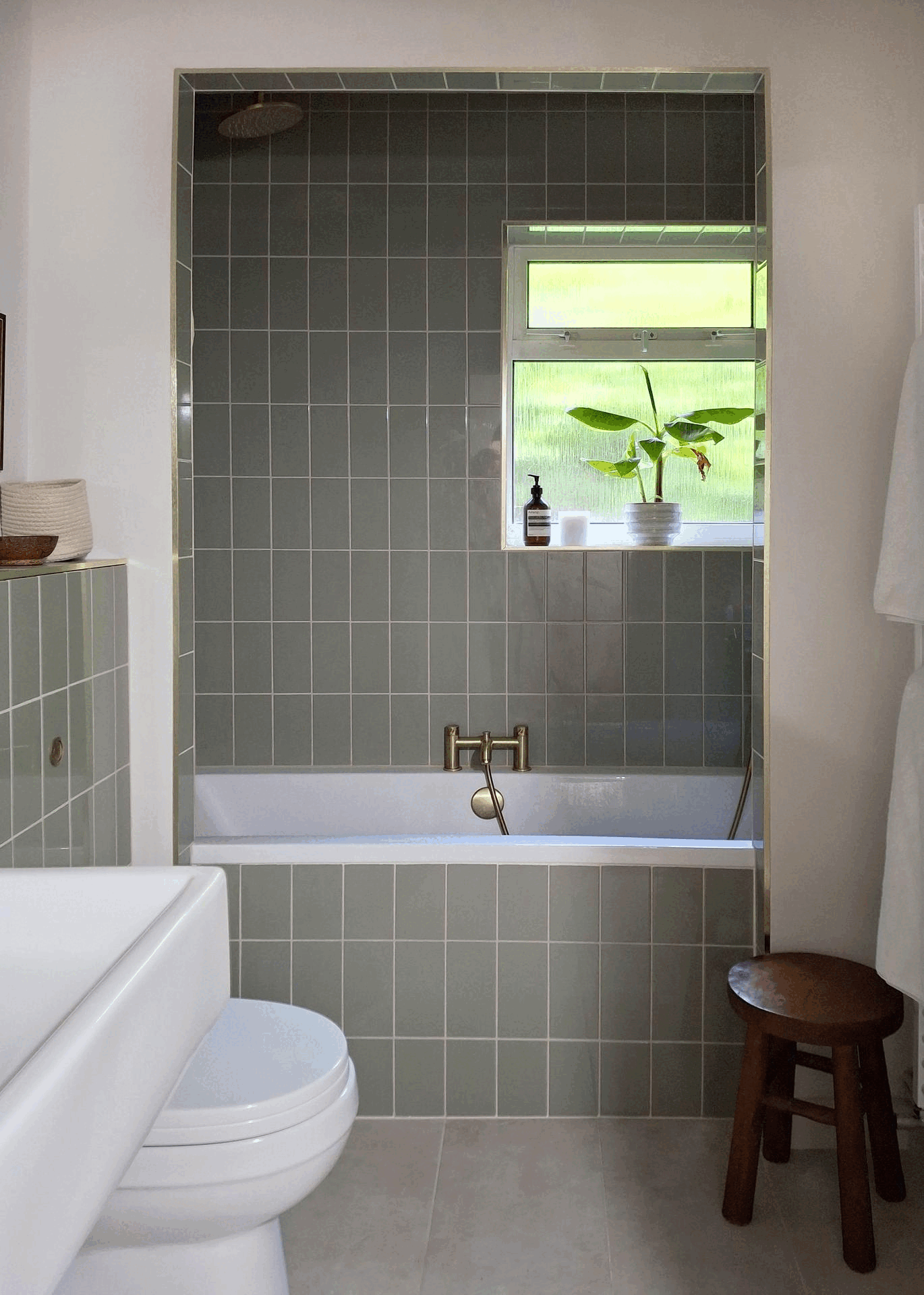 gif of a bathroom with built in bath, shower curtain hidden, then half open then fully closed