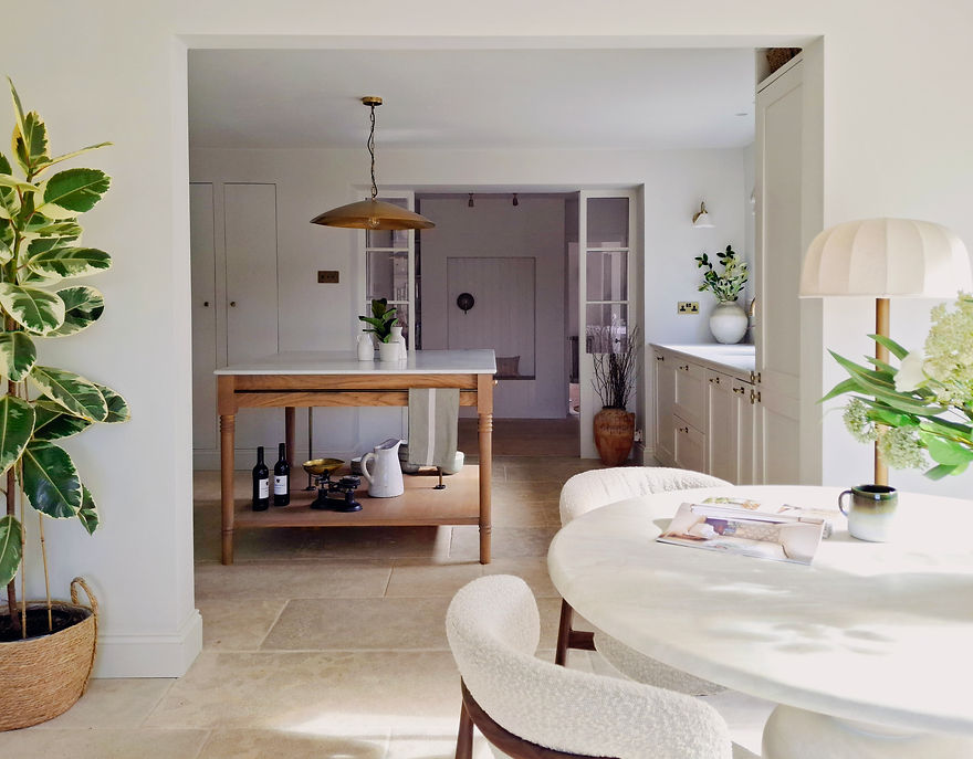 Neutral kitchen with stone floor and dining table, oak island