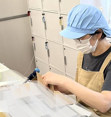プライドの請け負う文房具の組立作業。組んだノートをかしめる作業風景。ここだけは支援員の仕事。