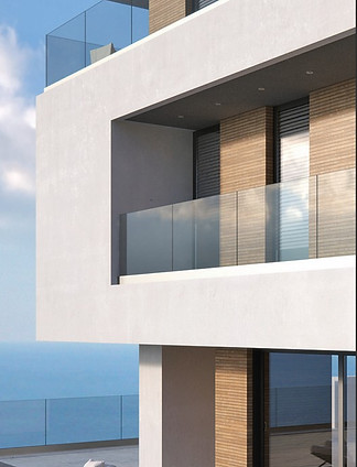 Модерен стъклен парапет без рамки, монтиран на балкон на минималистична сграда с морски изглед.