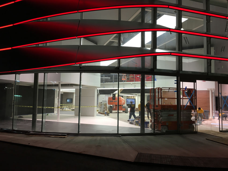 The dynamic facade of Porsche consists of 4 transitioning panels in each row, represented in Red, Yellow and Orange color, helps to get natural light and makes a visual connection between interior and exterior. The opening in the aluminium facade widens as we go down from the apex of the building to the entrance. The bottom of each row is connected with red LED lights to signify the entrance.