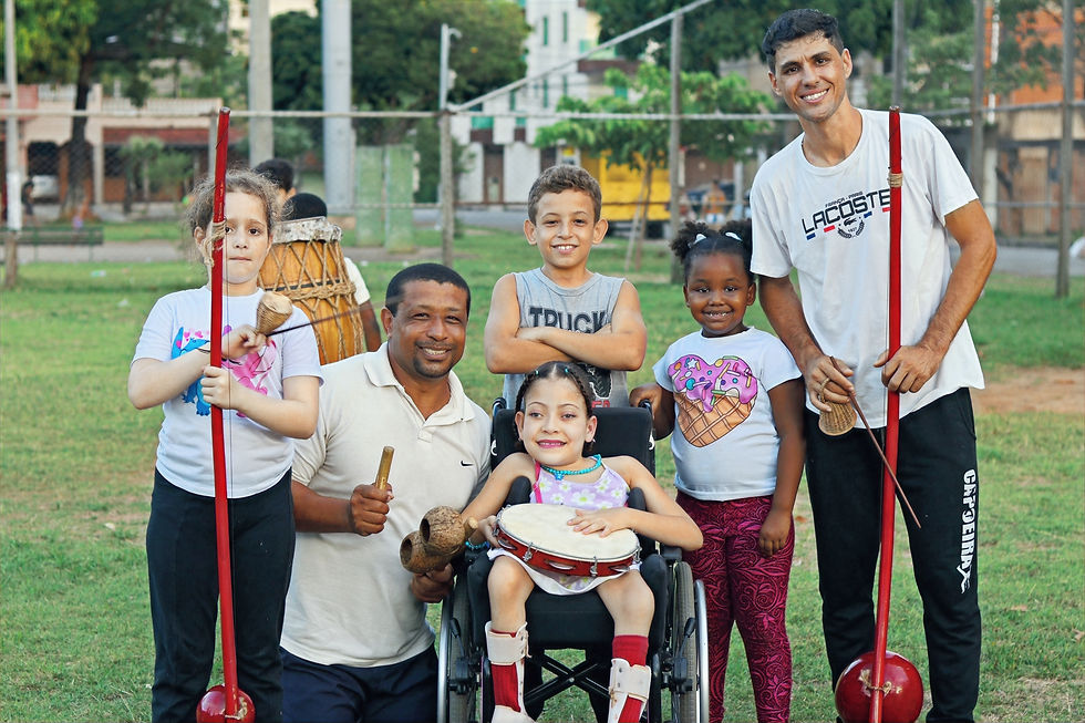 Capoeira inclusiva com crianças e professor durante atividades do Projeto Lutando Pela Vida da AIDÊ.
