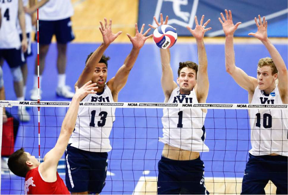 volleyball players blocking a volleyball