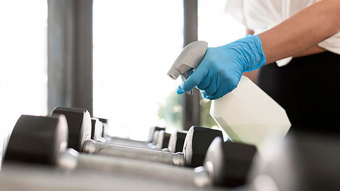 mujer-guantes-solucion-limpieza-desinfectante-pesas-gimnasio.jpg