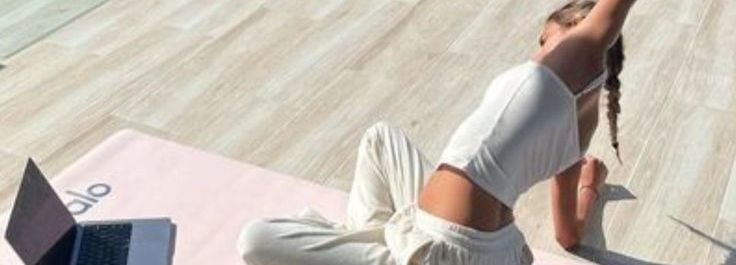 woman's hands in a meditating position, light by warm candles