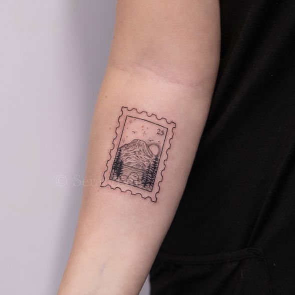 postage stamp fineline tattoo in delicate black and grey, featuring Mt Rainier and forest, created by Seraphim in Seattle, WA.