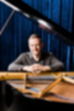 Mack sitting at the piano.