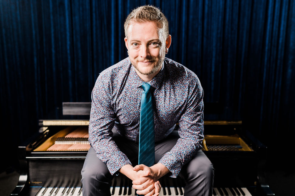 A photo of Mack wearing a tie sitting on top of a piano.