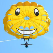 Smiley yellow parasail soaring high over Lake Huron during sunset.