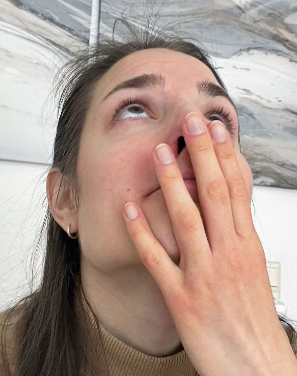 Frau hält Hand vor das Gesicht