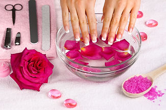 Beautiful woman's hands with french manicure in bowl of water with rose petals.jpg