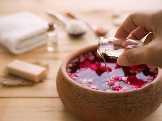 Hand pour coconut oil in to aroma smell rose with blur image of soap, towel, massage oil,