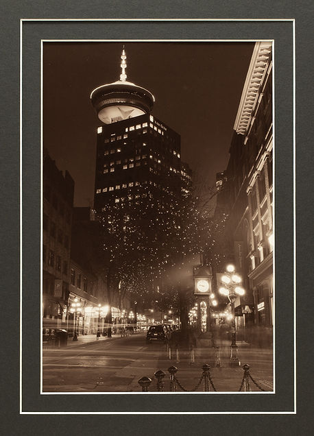 toned darkroom print of image showing the steam clock in gastown vancouver canada at night